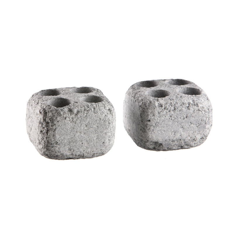 Two soapstone rocks with holes used to promote steam in saunas.