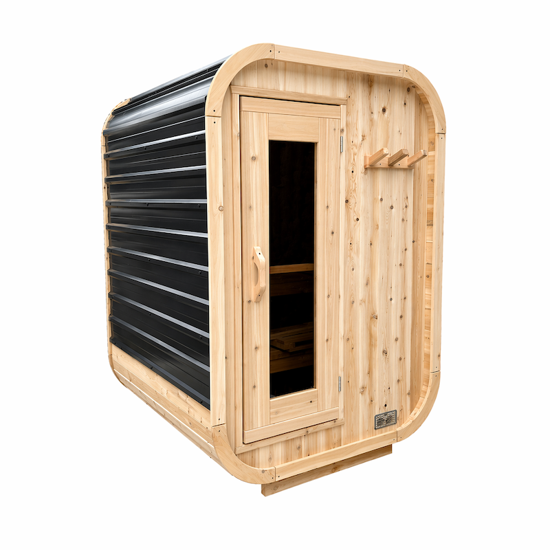 A small, modern, outdoor, cedar cube sauna made with a glass door and a metal roof.
