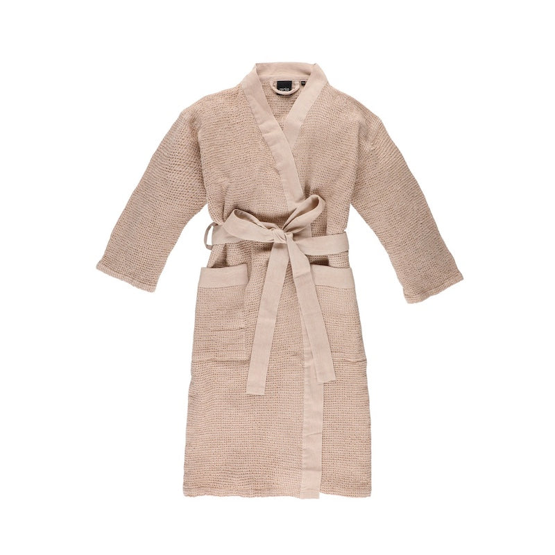 The front of a beige waffle knit bath robe used in saunas.