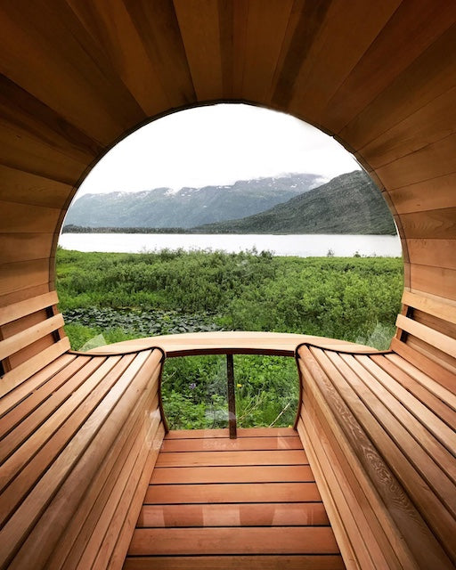 The inside of a Custom Henki Barrel Sauna overlooking a lake and mountains. 