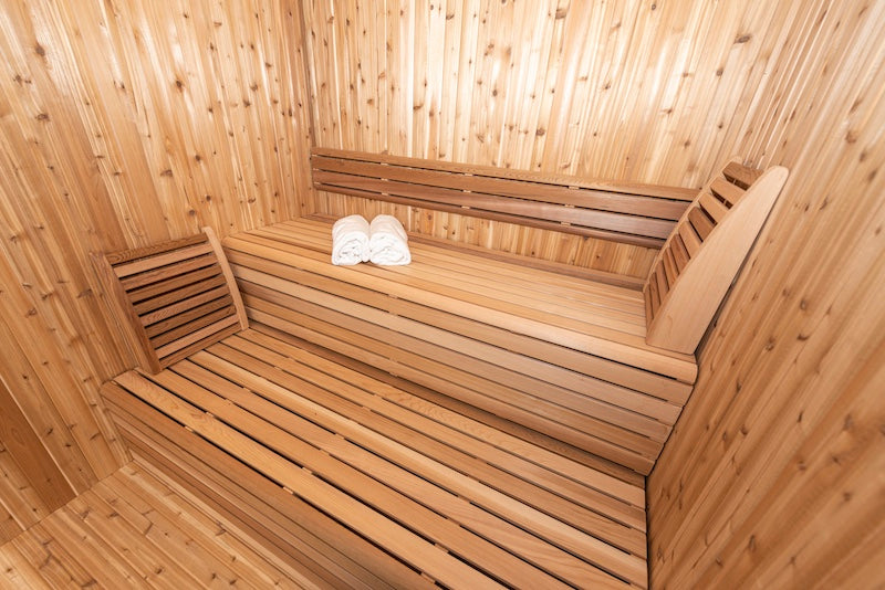 The clear cedar benches and back rests inside of a Pure Cube Hudson Sauna.