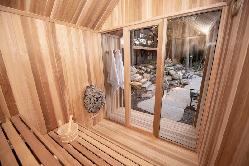 The clear cedar interior of a Pure Cube Hudson Sauna outside of a cottage in Muskoka.