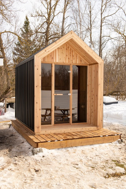 The Pure Cube Hudson Sauna on a small deck in the snow.