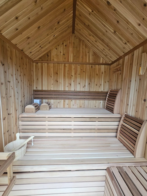 The interior benches of a Pure Cube Hudson Sauna with back rests and sauna accessories.