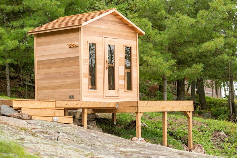 Henki's Modern Cabin Sauna on a deck over large rock.