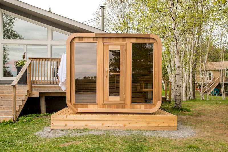 The front of Henki's Panoramic Cube Sauna next to a house in Ontario.