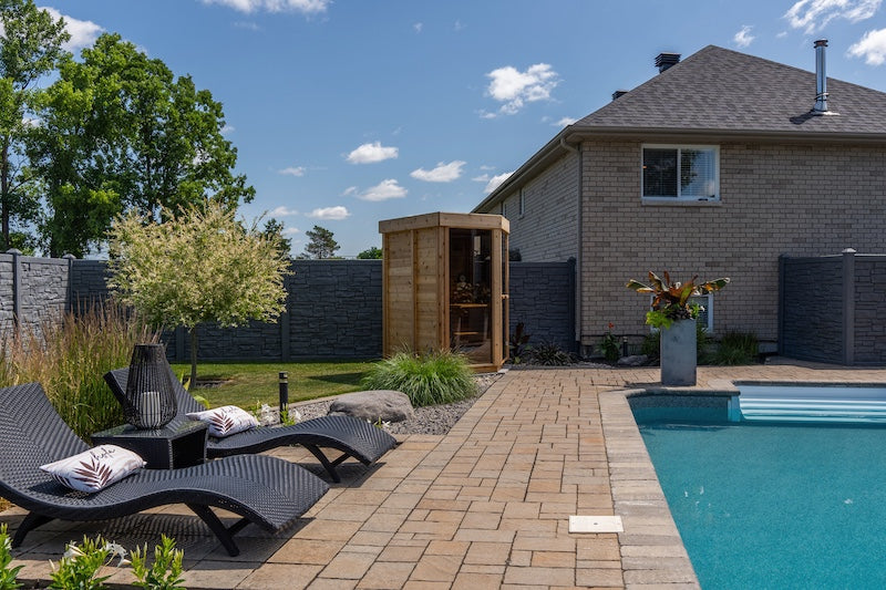 A Pure Cube Trinity Sauna from Henki next to a pool in Belleville. 