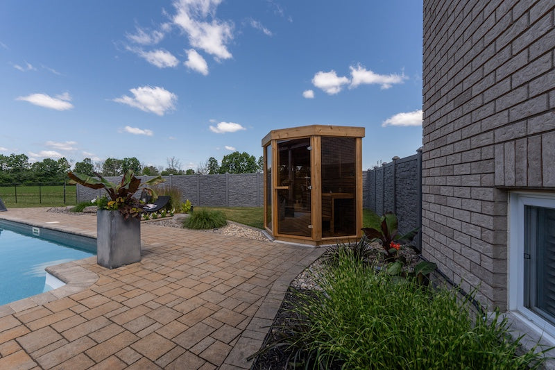 The Pure Cube Trinity Sauna on a pool patio in Ontario.