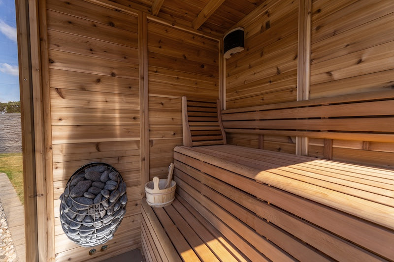 The interior of a Pure Cube Trinity Sauna with a Huum Drop sauna heater.