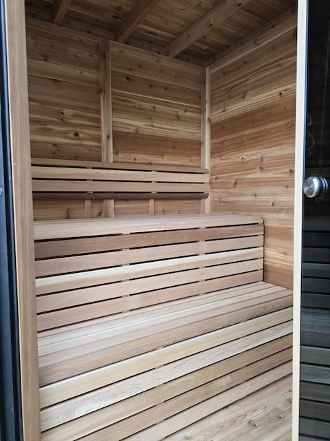 The inside of Henki's Pure Cube Trinity Sauna with clear cedar benches.