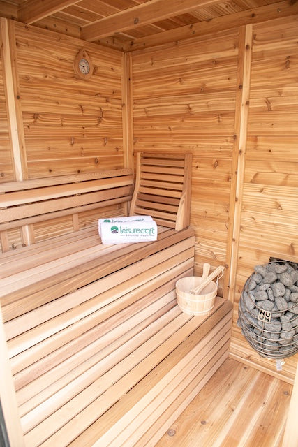 Inside of Henki's Pure Cube Trinity Sauna with sauna accessories on the benches.