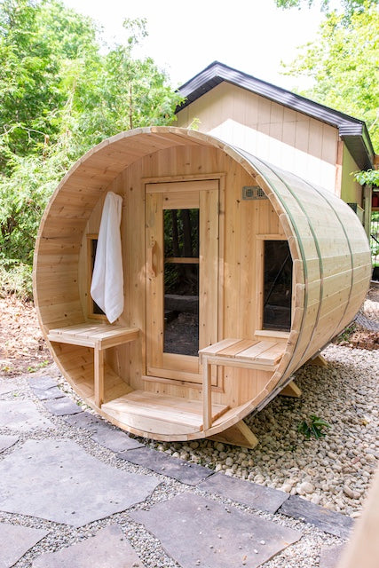 A Henki Window Barrel Sauna with a white towel hanging on the front.